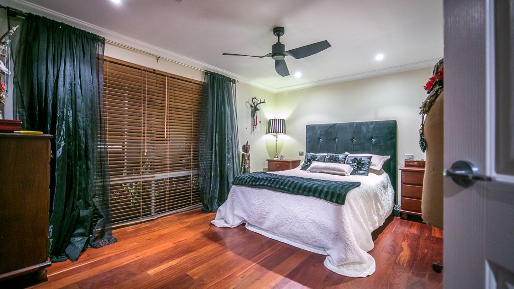 bedroom with hardwood floor, white bed, ceiling fan, blue curtains and wooden blinds
