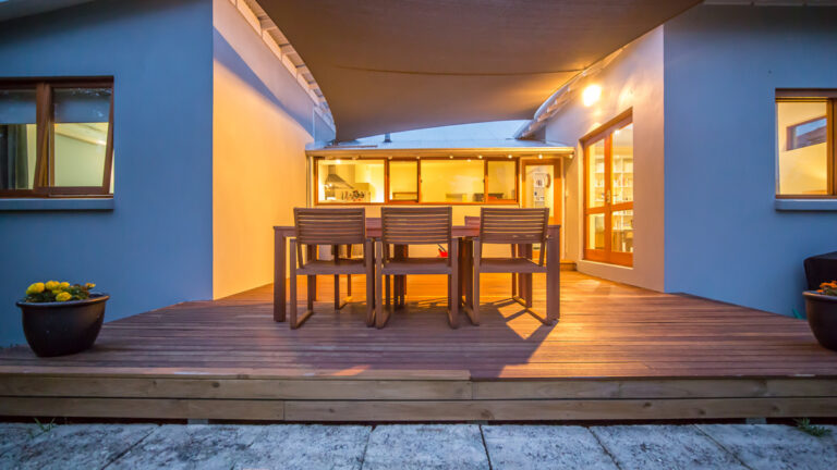 Wooden deck in behind house the evening with wooden alfresco dining chairs